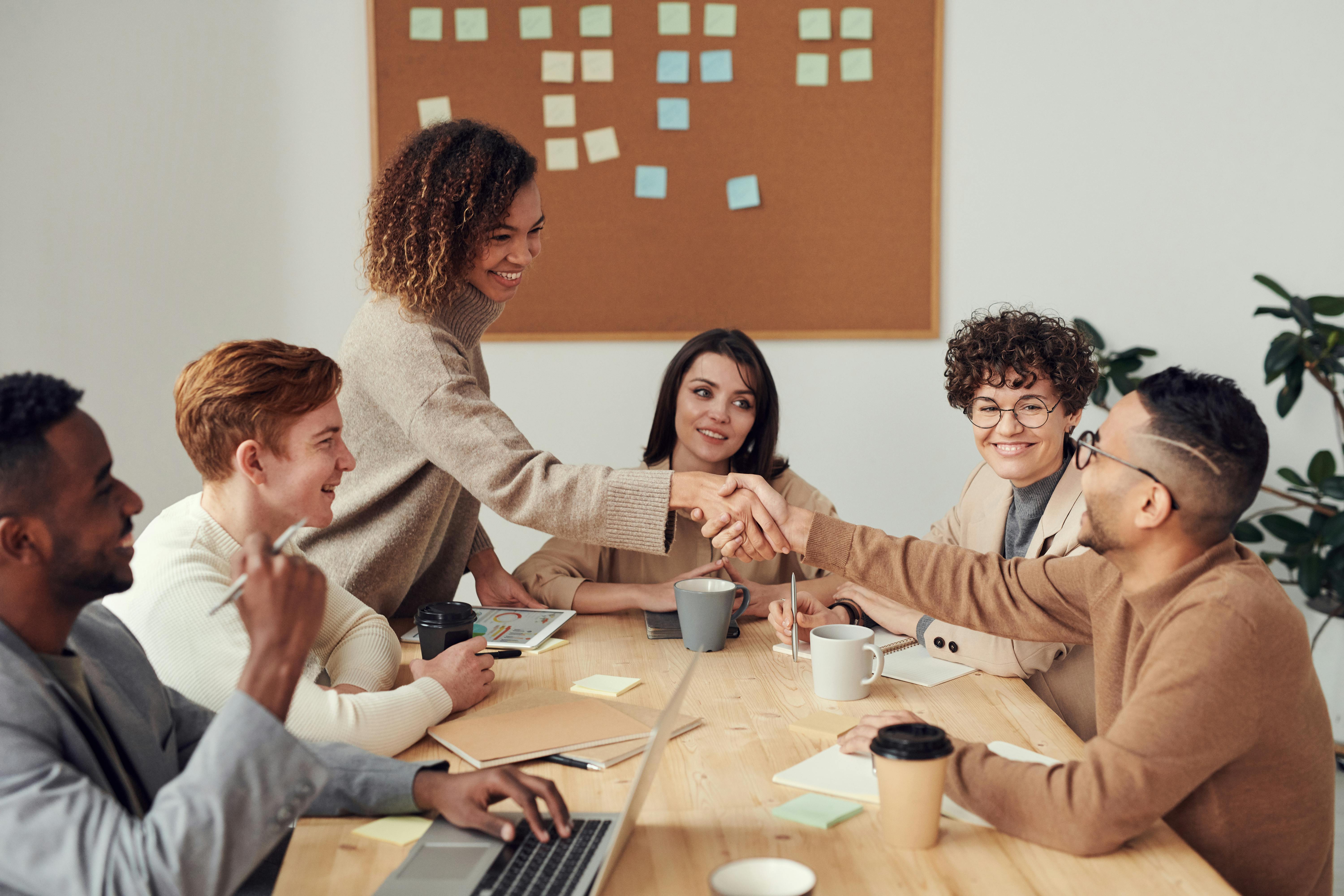 Group of people collaborating around a wooden table.